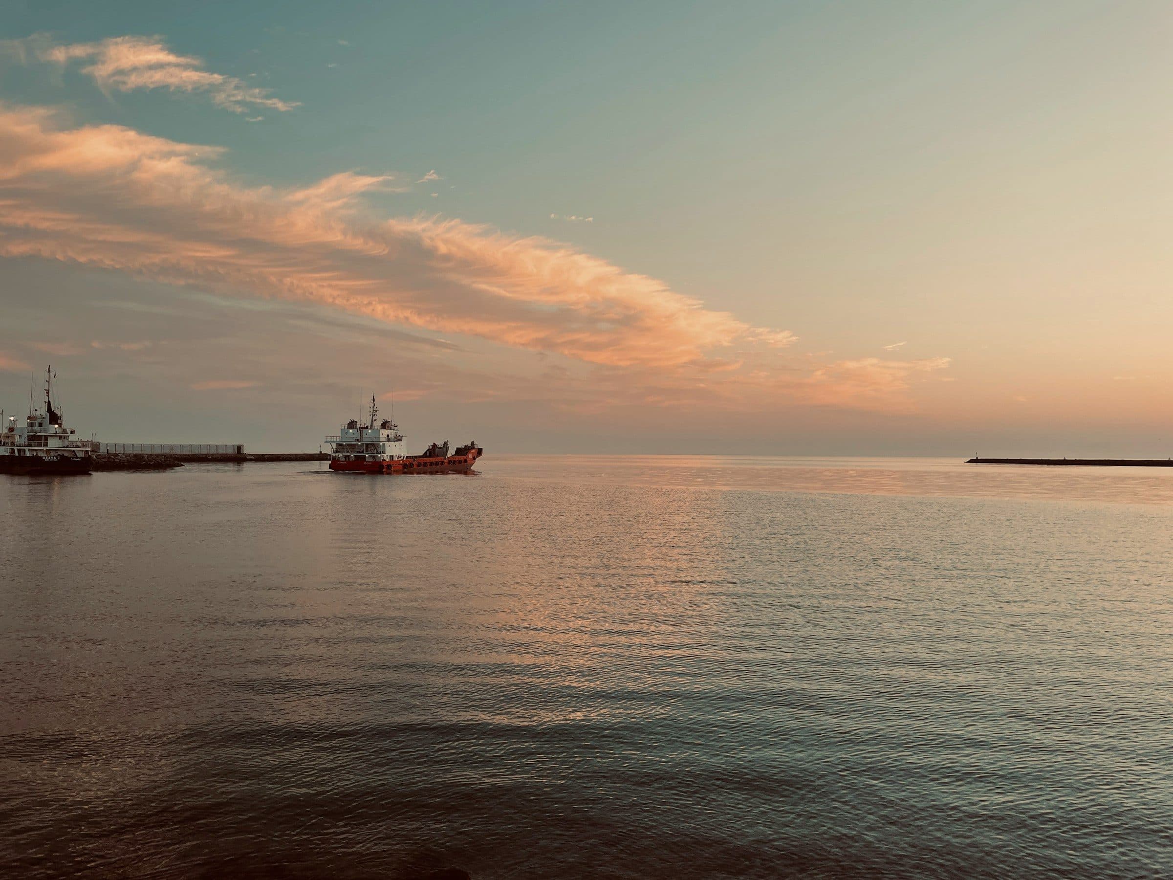 Cargo vessels heading out to sea at dusk