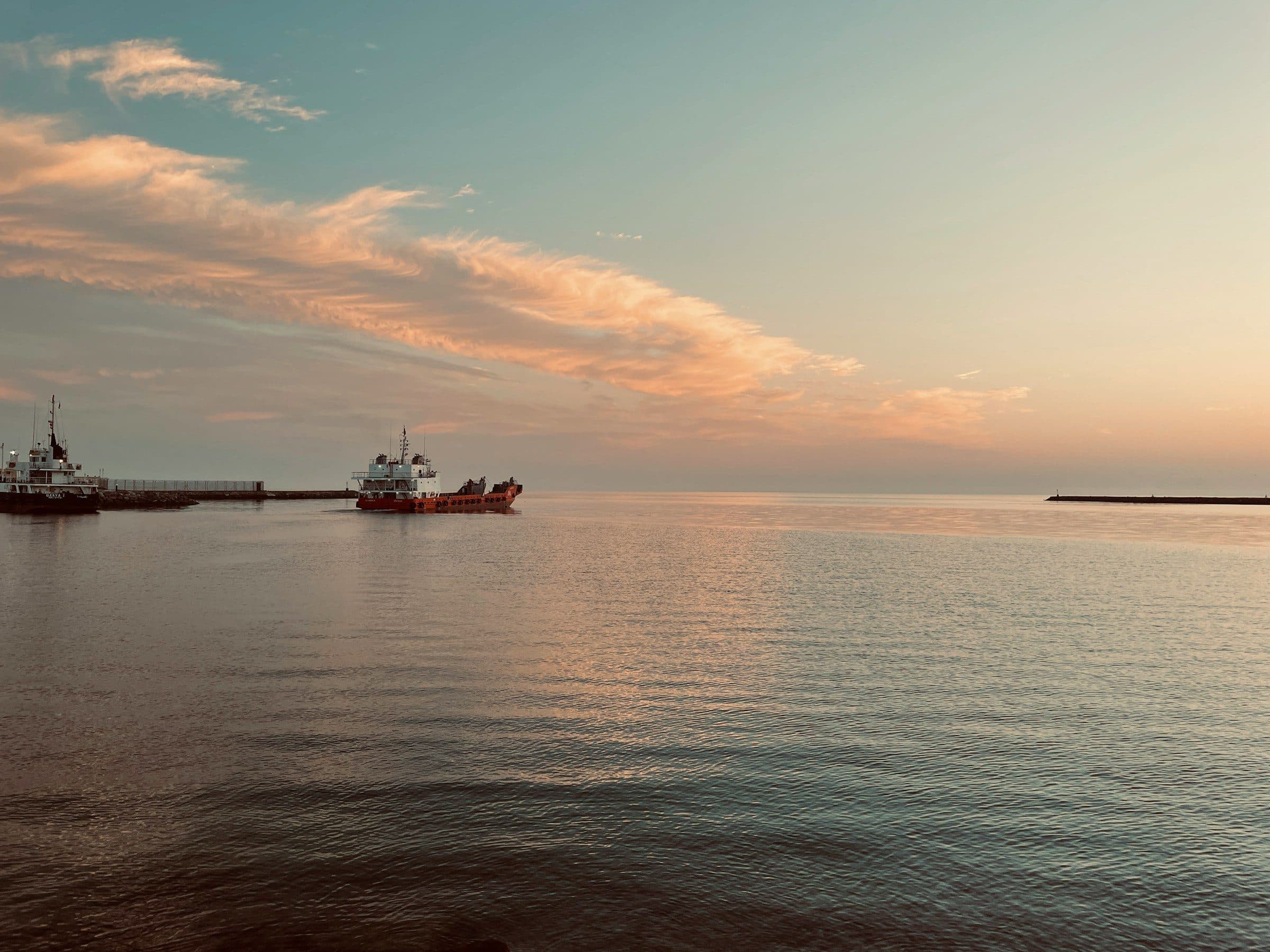 Cargo vessels heading out to sea at dusk